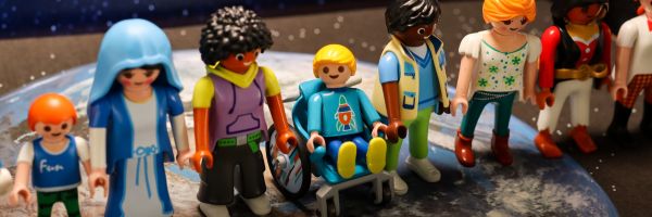 Playmobilfiguren stehen in einer Reihe zusammen auf dem Bild der Erde..