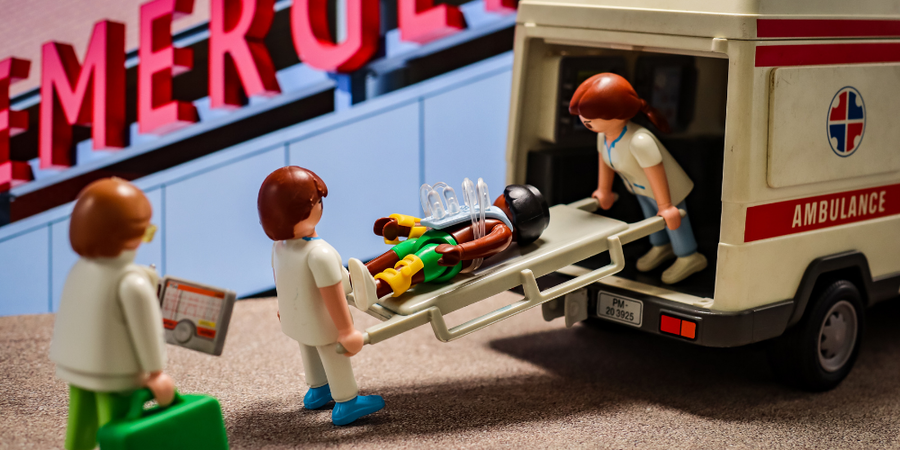 22- Eine Playmobilfigur wird auf einer Trage in einen Krankenwagen geladen.