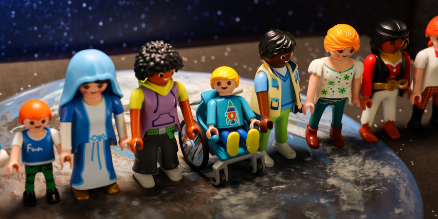 01- Playmobilfiguren stehen in einer Reihe zusammen auf dem Bild der Erde.